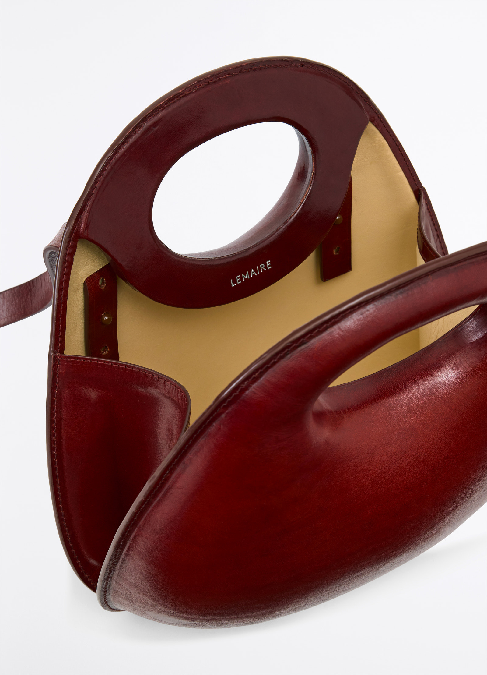 Lemaire egg bag in smooth vegetable-tanned cowhide, product shot, top interior view integrated handle detail