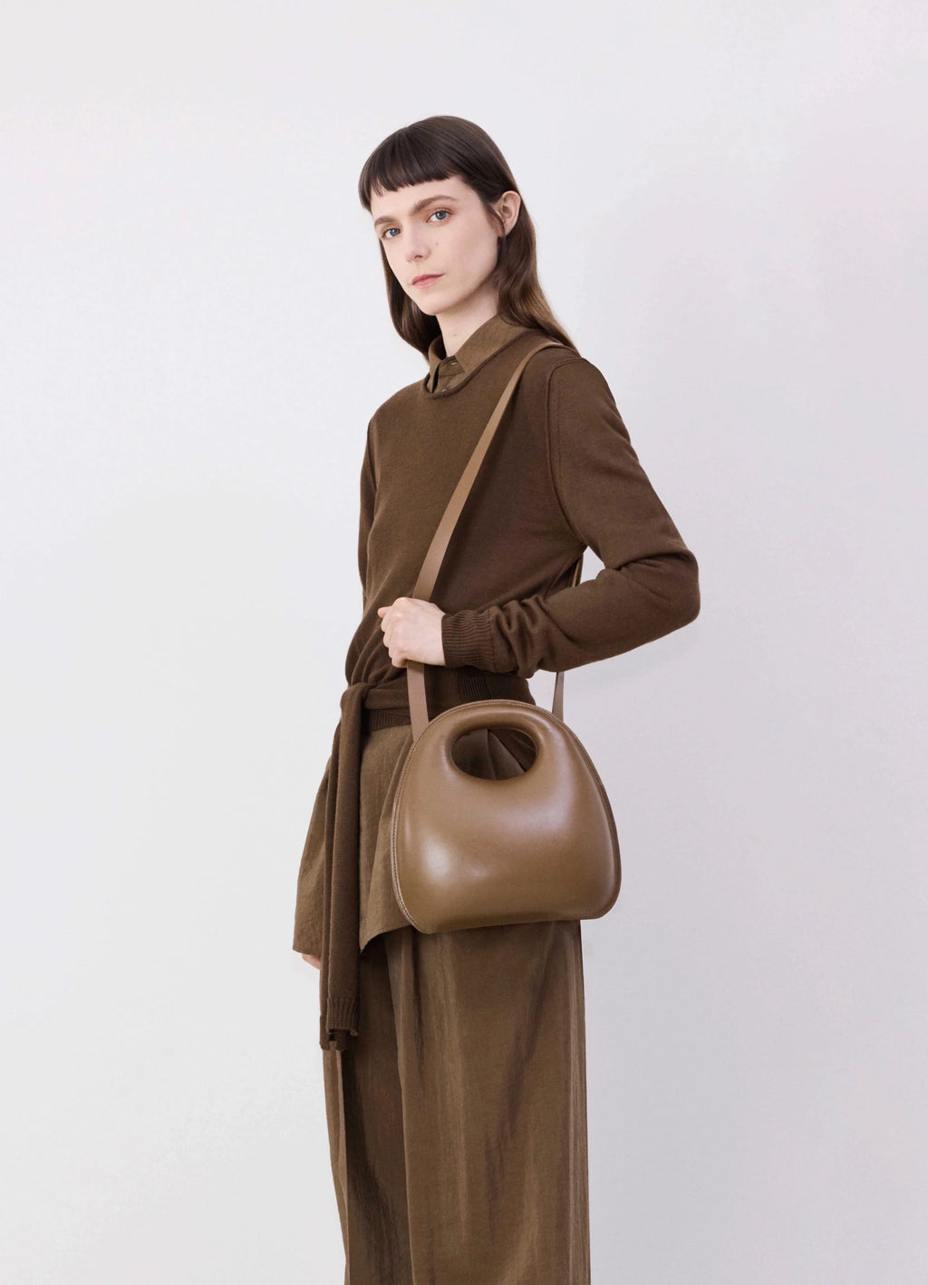 Lemaire Egg Bag in Smooth Vegetable-Tanned Cowhide, model shot, side view crossbody wear