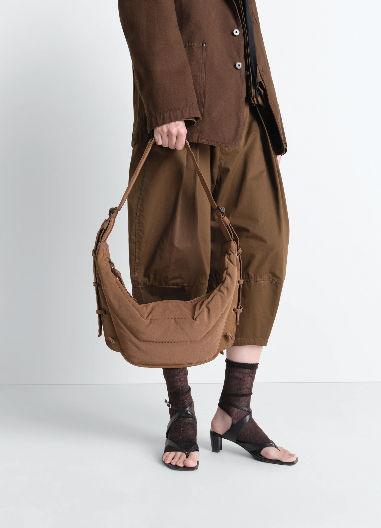 Small soft game bag in nylon canvas, model shot, front held view adjustable strap