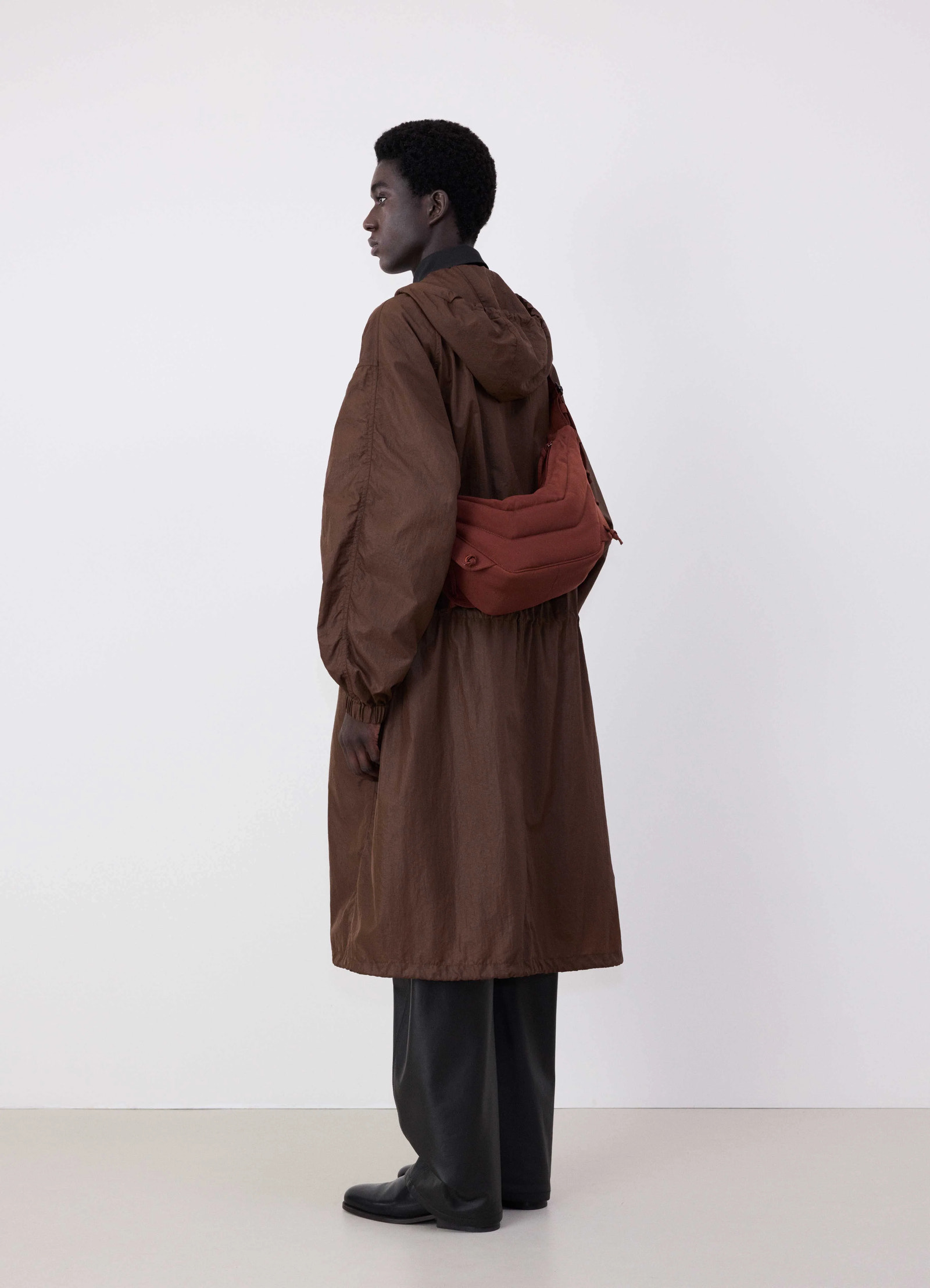 Small soft game bag in fluffy-nylon canvas, model shot, three-quarter back view sling shoulder