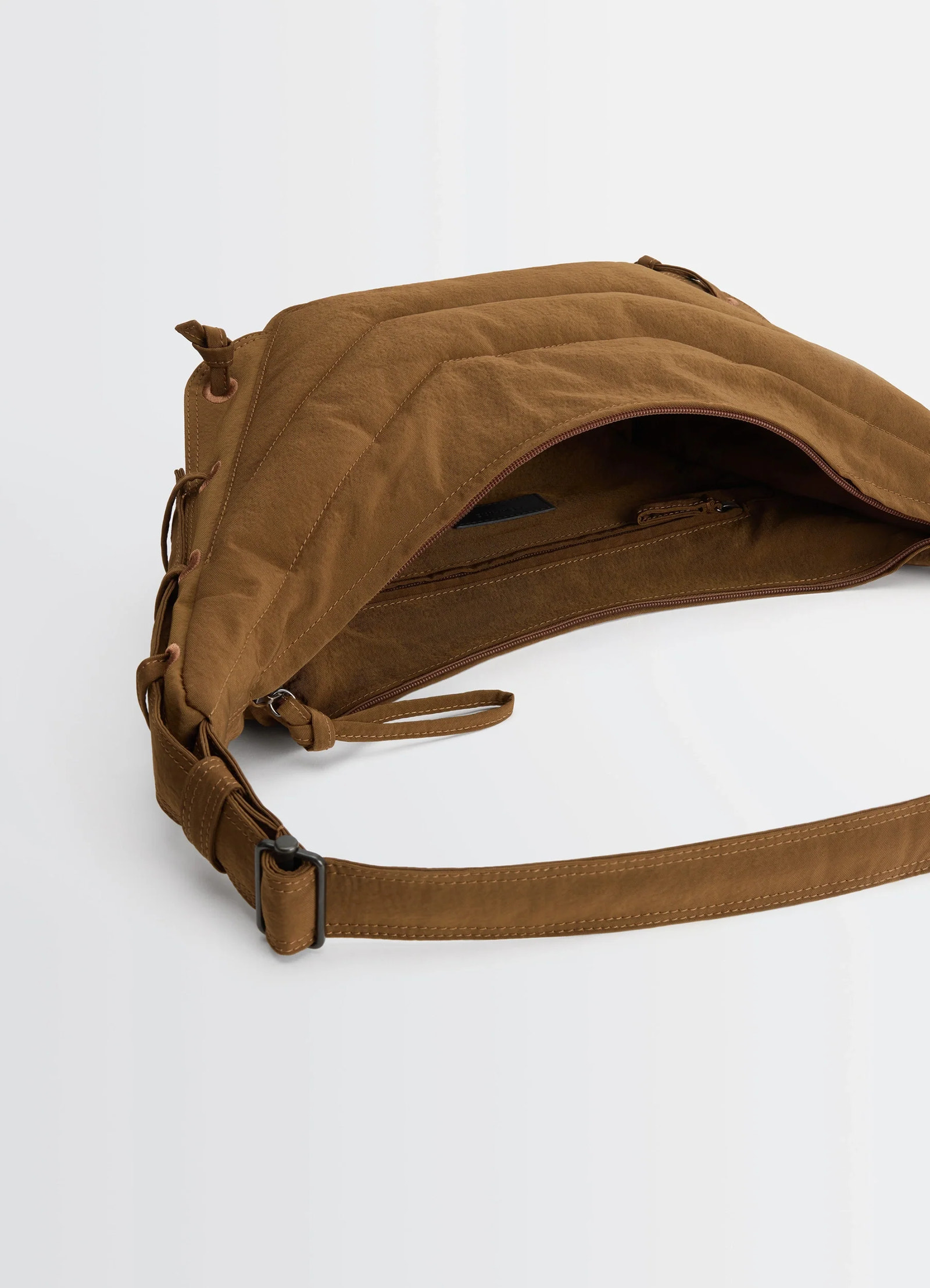 Small soft game bag in quilted water-repellent nylon, product shot, top detail view adjustable strap, open top