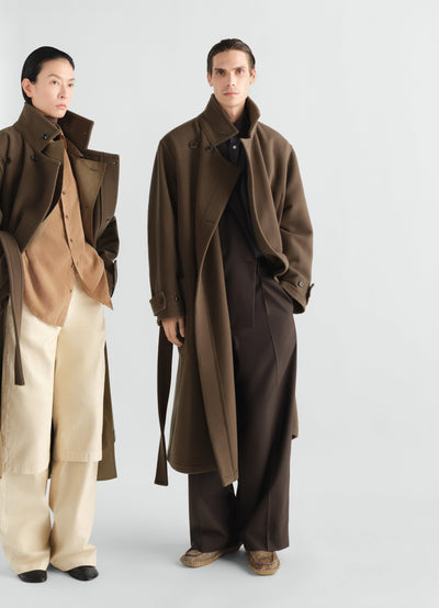 Wrap coat in brown wool worn by male model with dark trousers and shirt LEMAIRE styled look