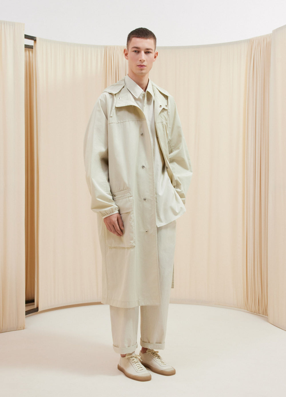 Lemaire Long Water Repellent Parka in Light Cotton Gabardine, model shot, front view convertible hood with large pockets