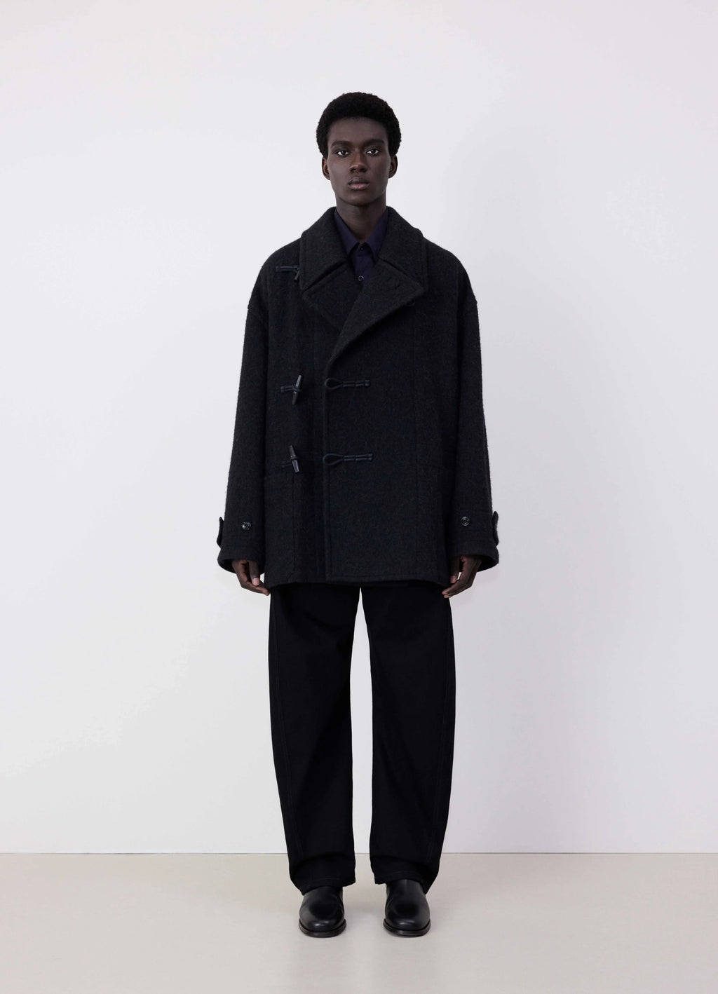 Lemaire Short Duffle Coat in Black Wool and Alpaca Mix, model shot, Front view Boxy silhouette, three toggle