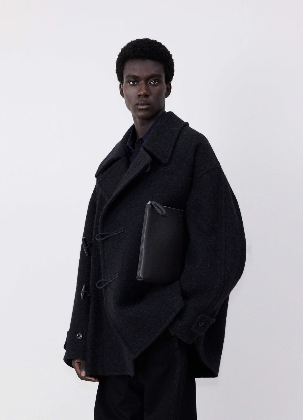 Lemaire Short Duffle Coat in dark wool and alpaca mix, model shot, front side view boxy silhouette, toggle