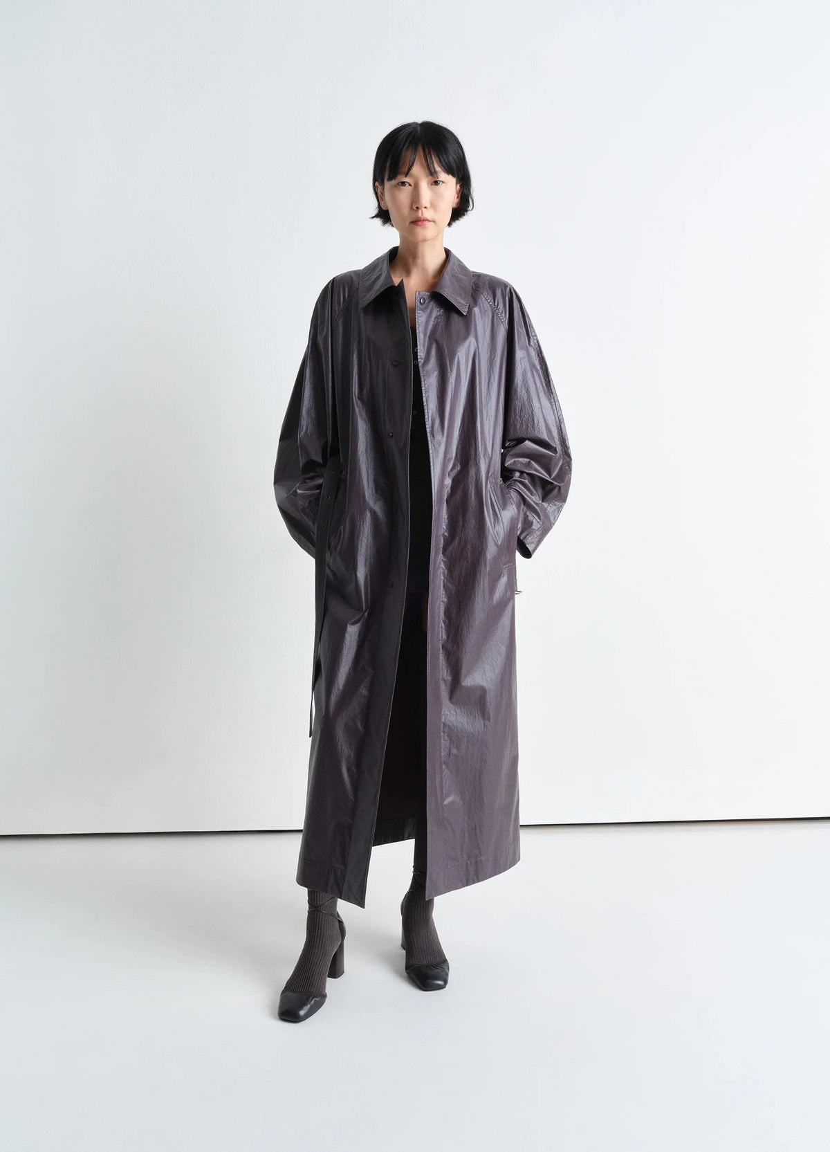 Lemaire Light Belted Coat in Light Coated Cotton, model shot, front view adjustable belt, shiny finish