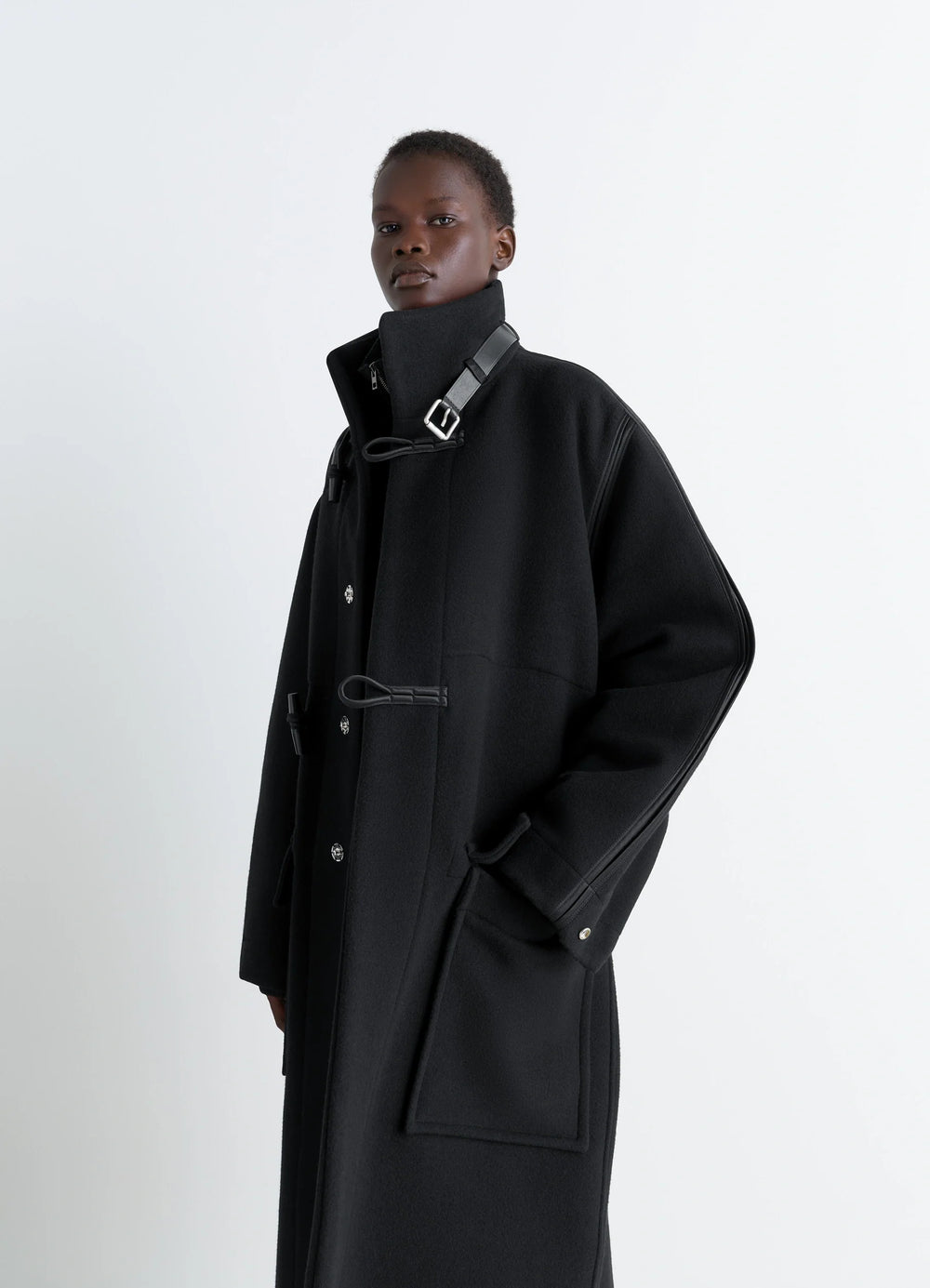 Lemaire Duffle Coat in Double-faced wool black, model shot, side view leather toggle closure