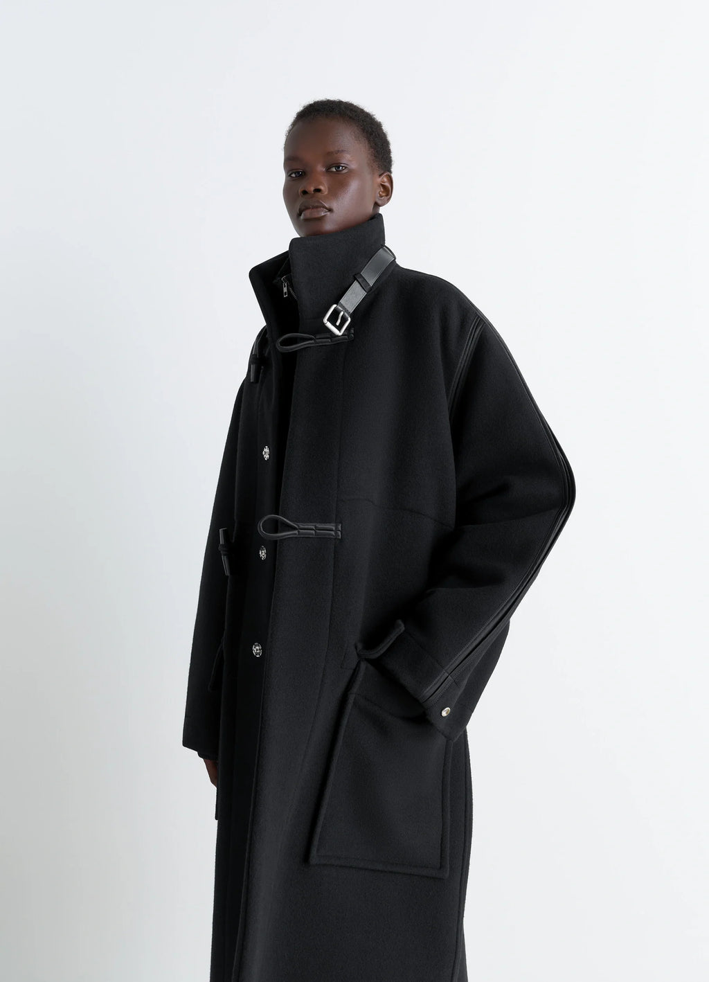 Lemaire Duffle Coat in Double-faced wool black, model shot, side view leather toggle closure