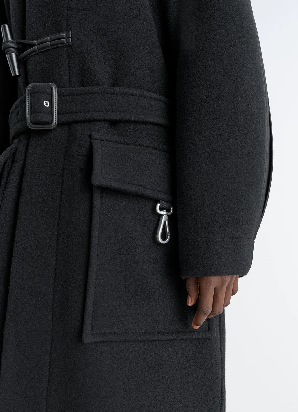 Lemaire Duffle Coat in Double-faced wool black, model shot, lower half detail view metal clasp pocket detail