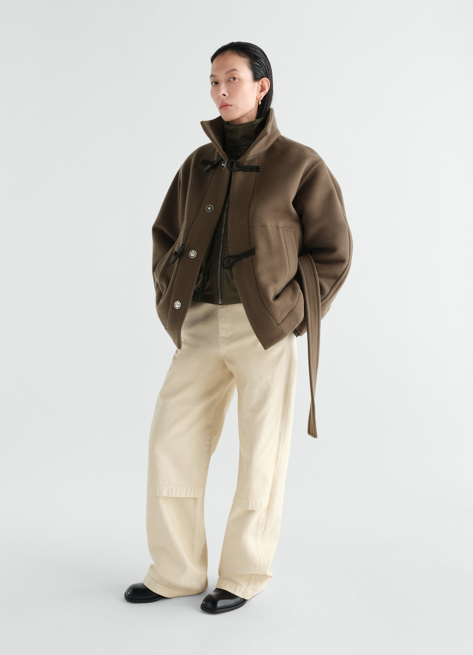 Short brown wool duffle coat with toggle fastening worn by a model front view lemaire