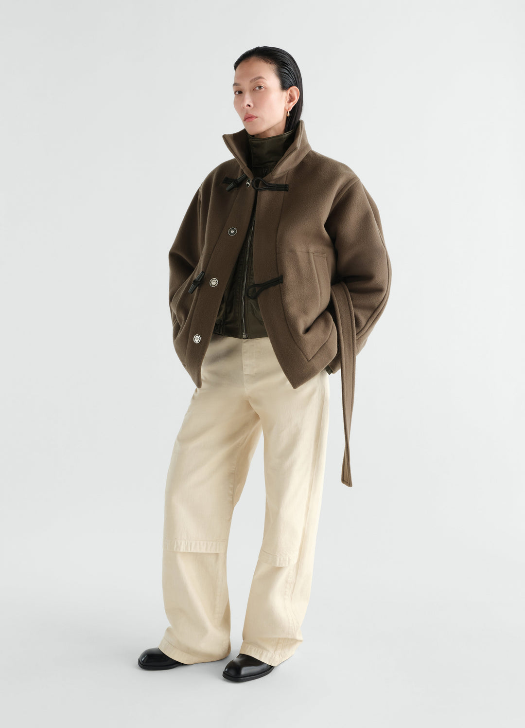 Short brown wool duffle coat with toggle fastening worn by a model front view LEMAIRE