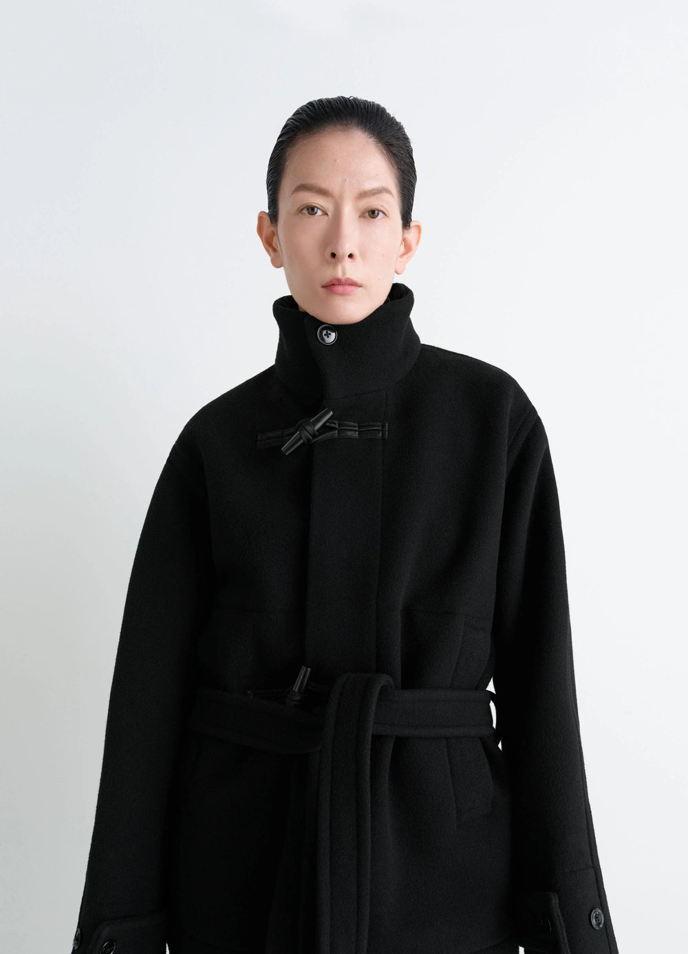 Lemaire Short Duffle Coat in Black Double-faced Wool, model shot, upper body front view high collar knot toggle