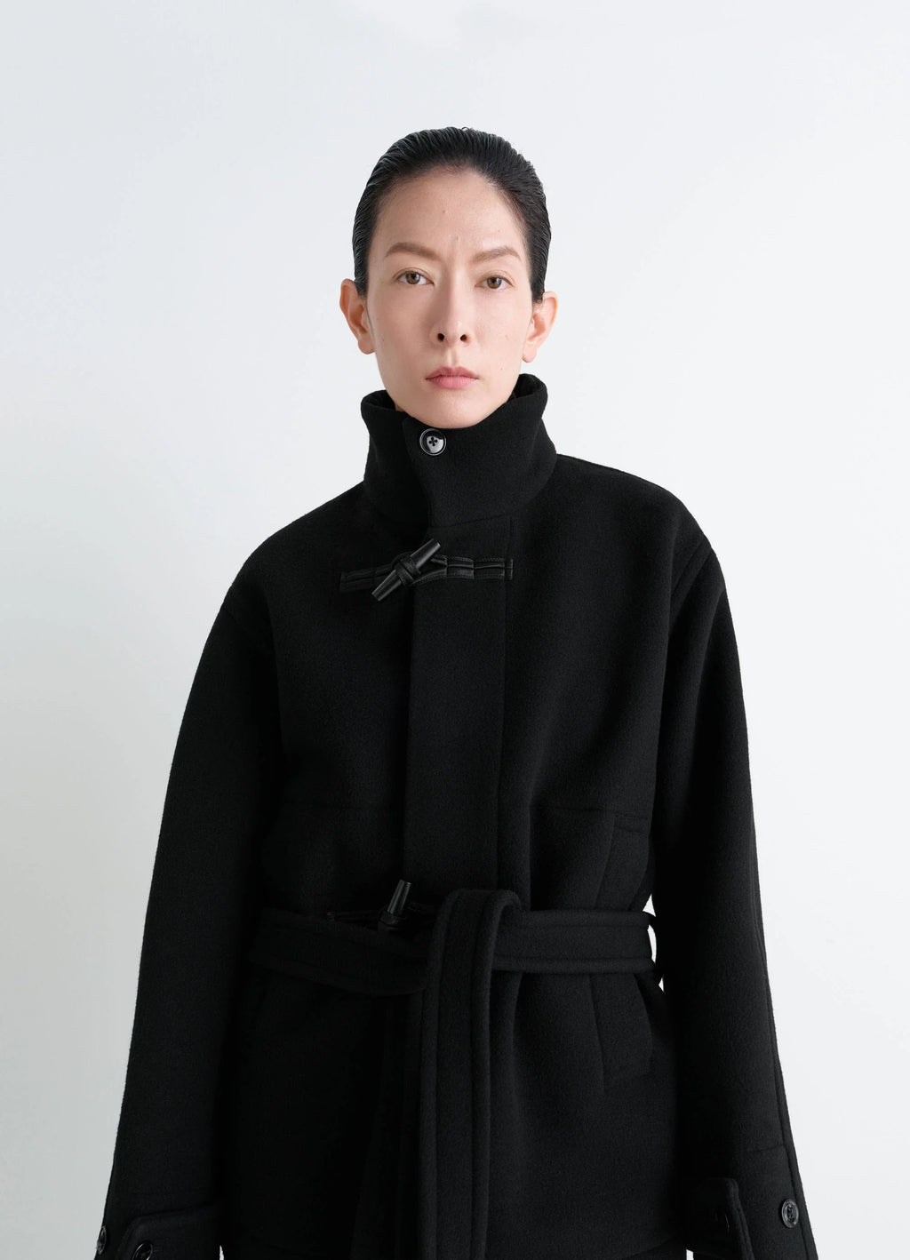 Lemaire Short Duffle Coat in Black Double-faced Wool, model shot, upper body front view high collar knot toggle