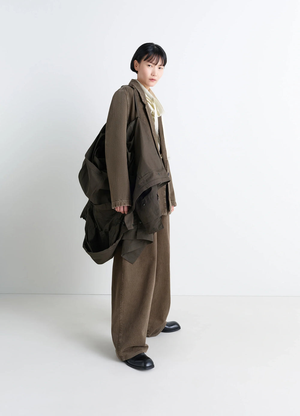 Lemaire Utility Raincoat in Khaki Linen Cotton Blend, model shot, back three-quarter view draped over shoulder