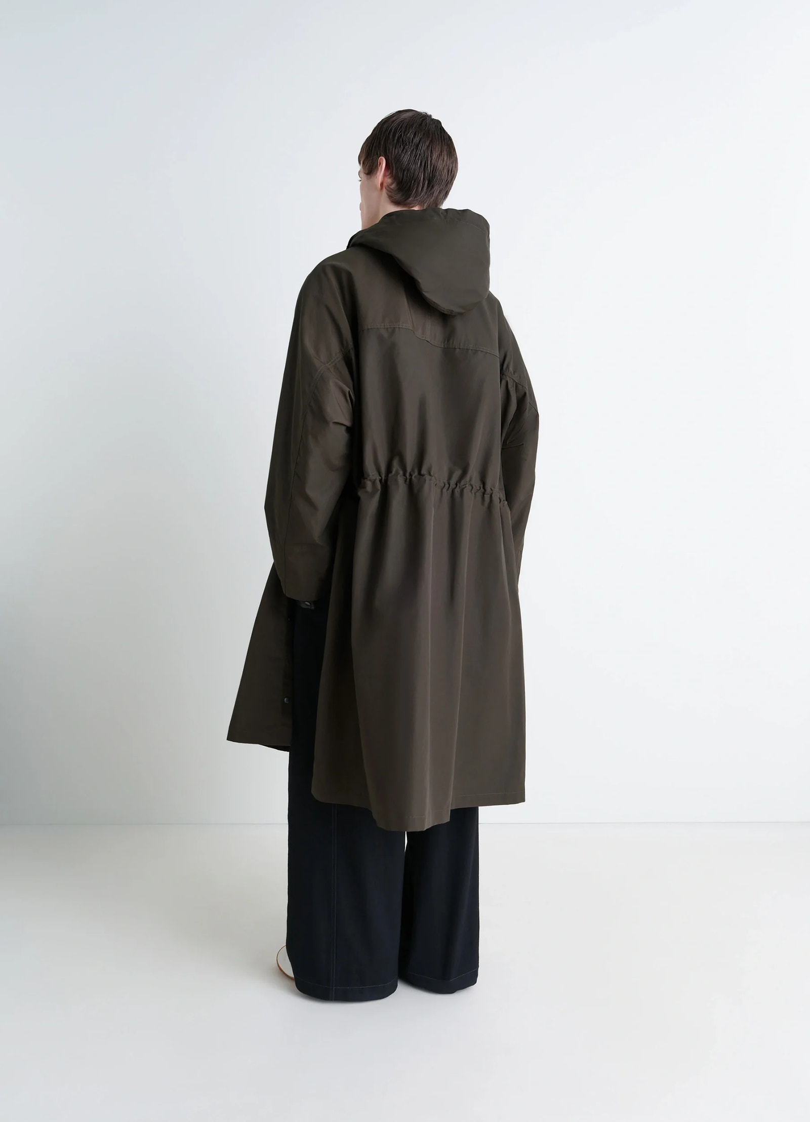 Lemaire utility raincoat in khaki linen cotton blend, model shot, back view cinched waist, relaxed fit