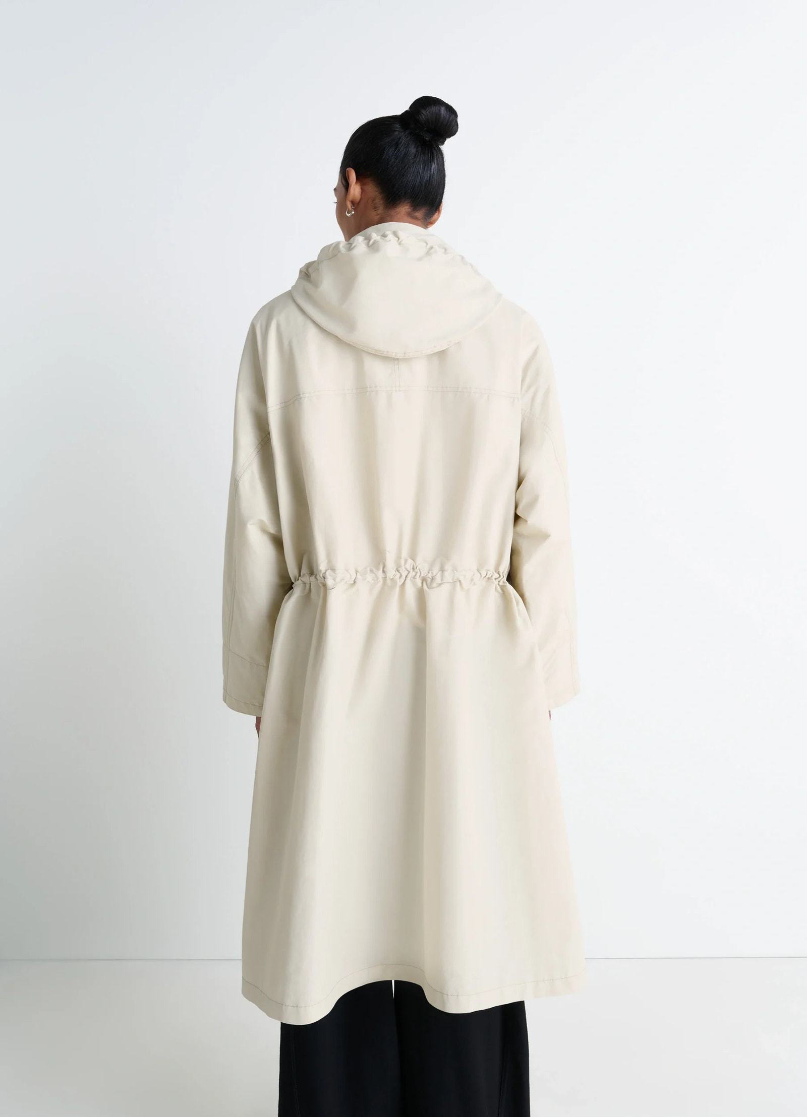 Lemaire utility raincoat in beige linen cotton blend, model shot, back shoulder view hooded waist drawstring