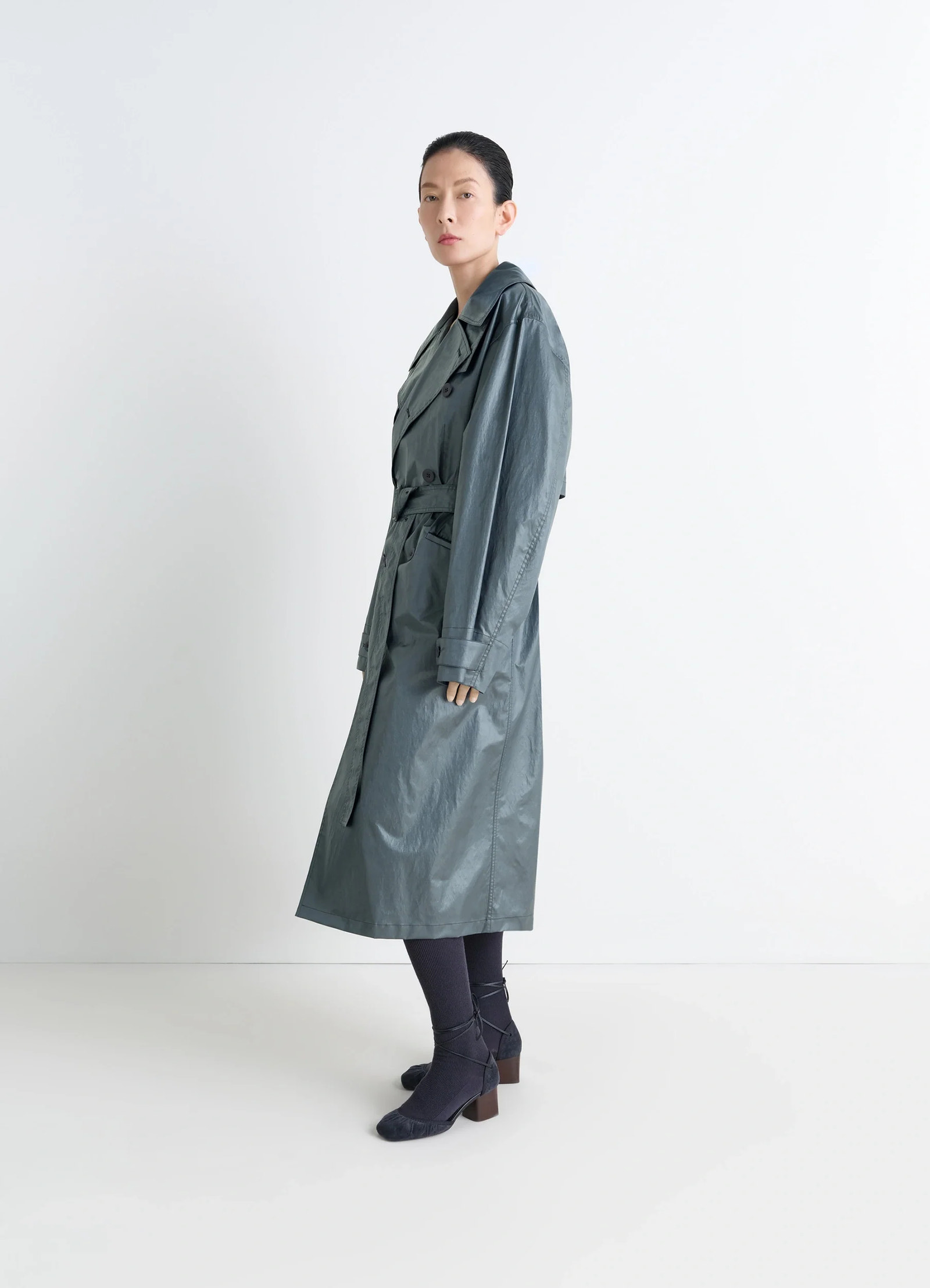 Oversized trench coat in metallic coated cotton, model shot, side view double-breasted buttons