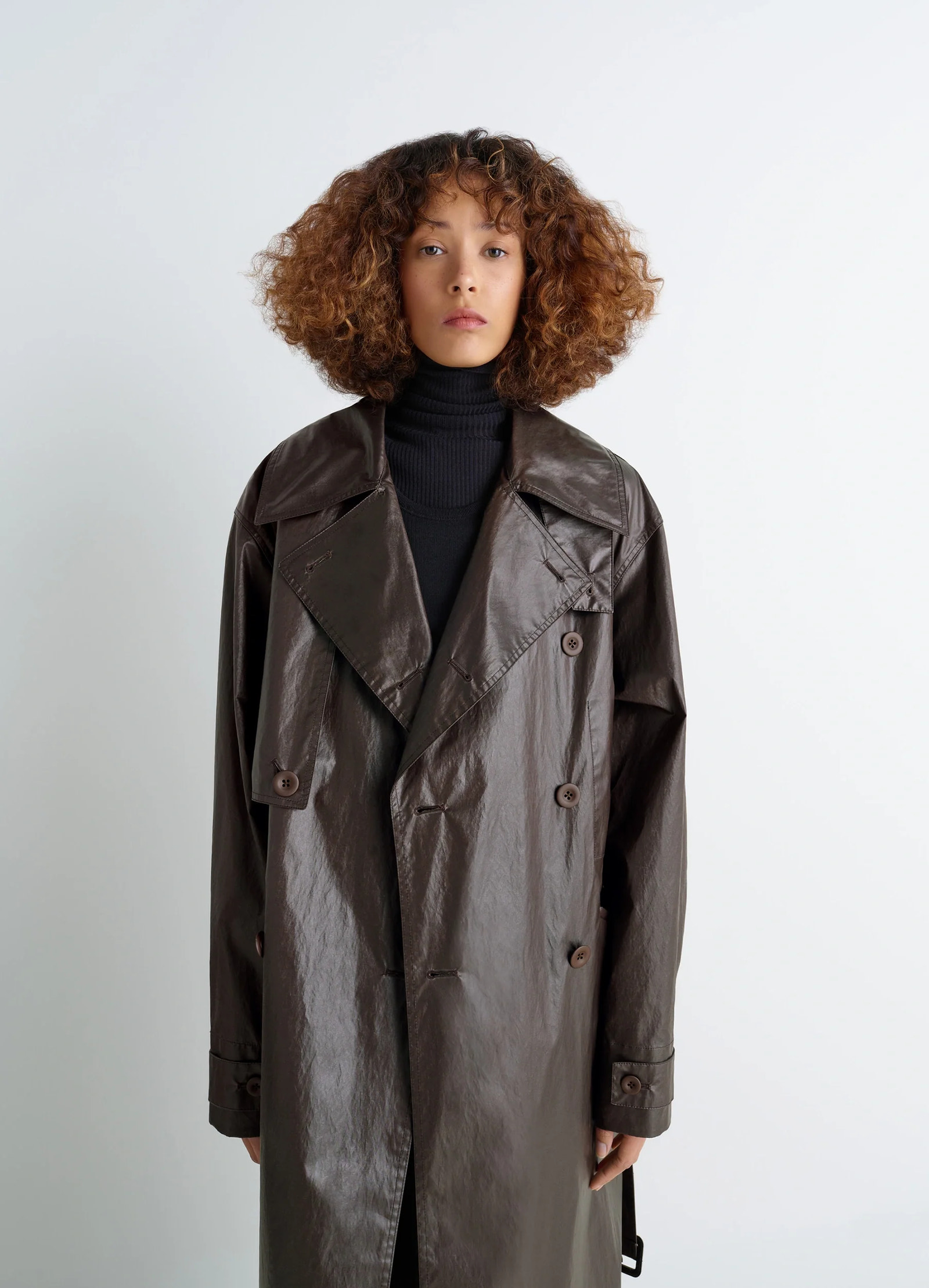 Oversized trench coat in metallic coated cotton, model shot, close-up view double-breasted buttons