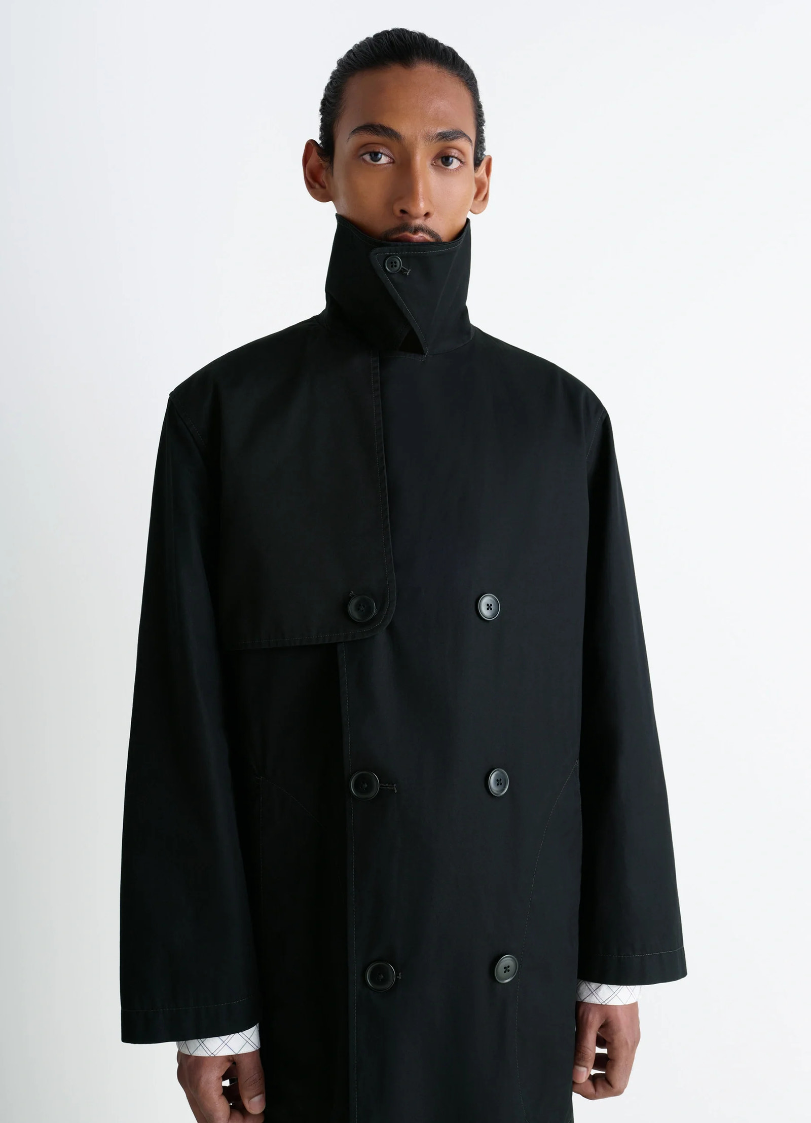Ventile trench coat in black ventile cotton, model shot, three-quarter view buttoned collar detail