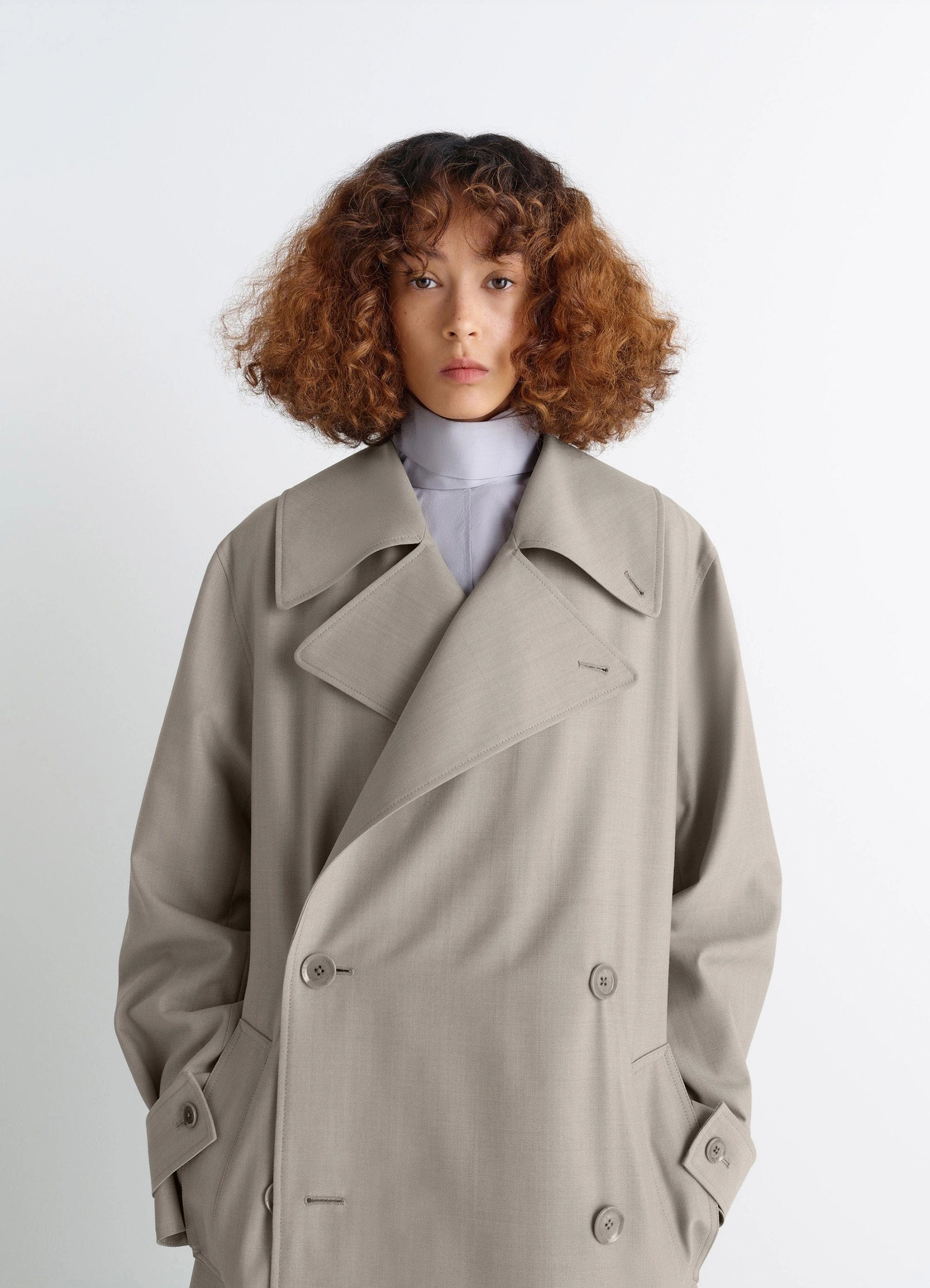 Lemaire trench coat in tropical wool-blend mottled, model shot, close-up view large lapels, double-breasted