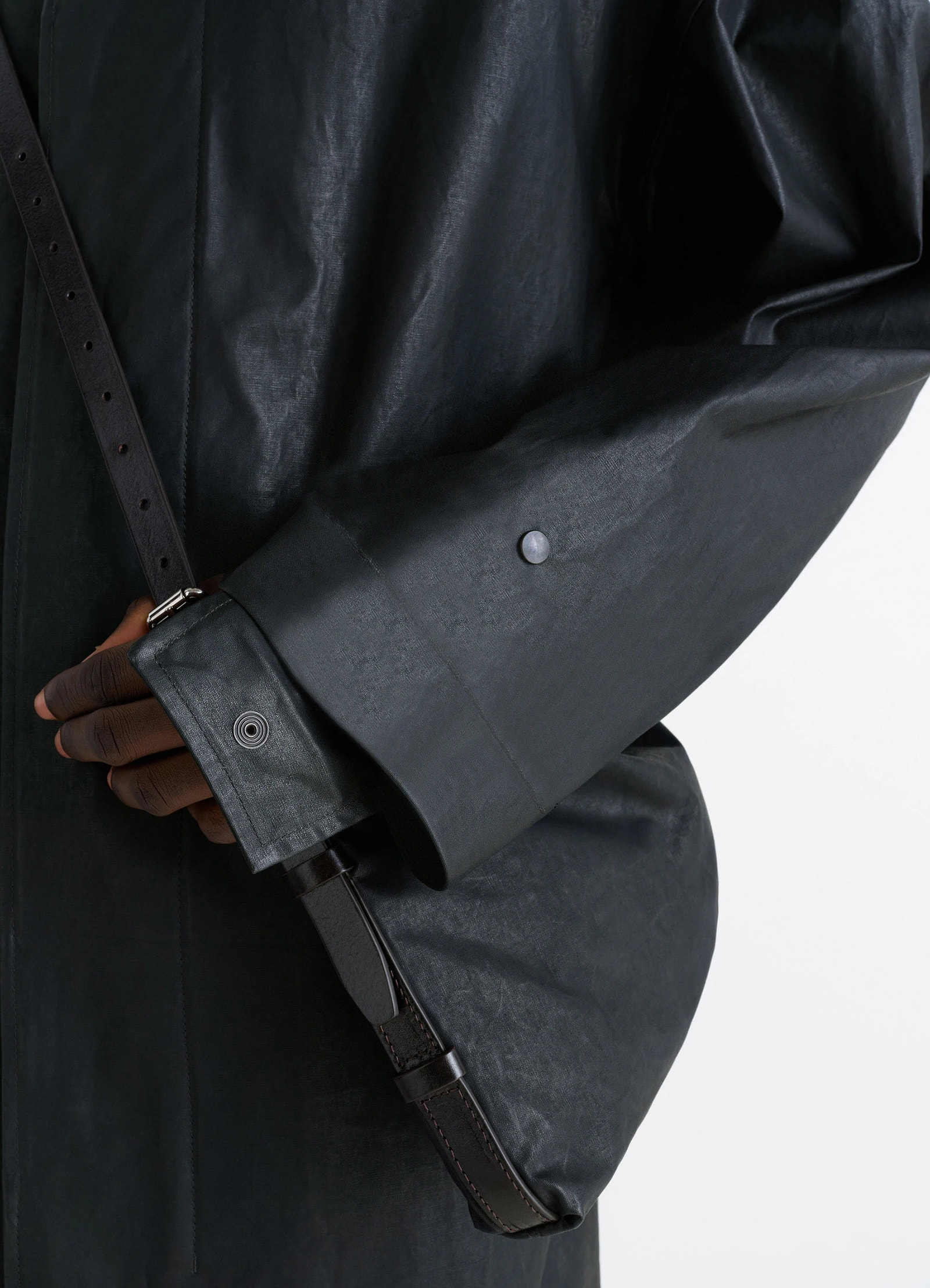 Hooded raincoat in water-repellent resinated cotton, model shot, detail shot cuff with snap button