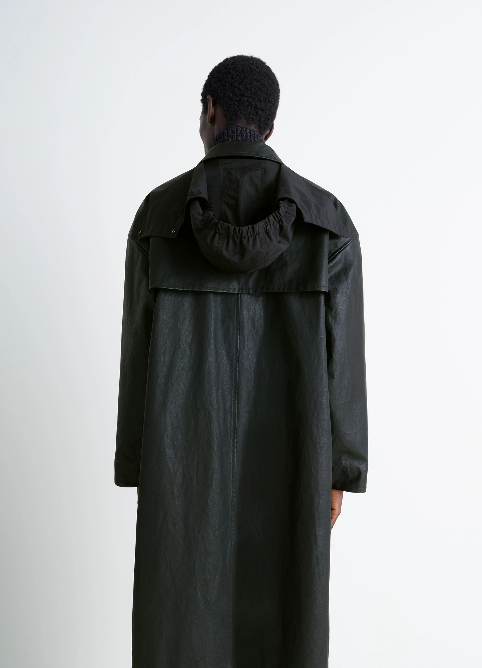 Hooded raincoat in water-repellent resinated cotton, model shot, rear close-up with collar hood and collar detail