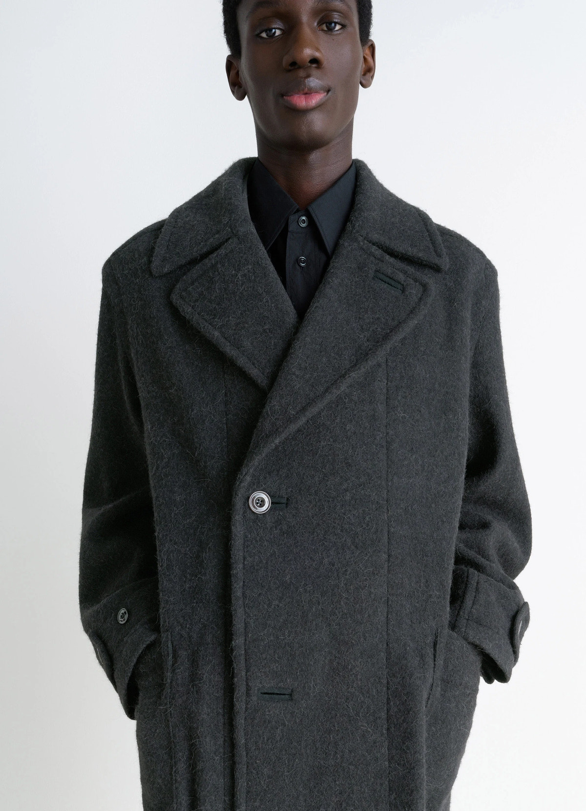 Soft coat in dark wool alpaca blend, model shot, close-up view button detail, pocket