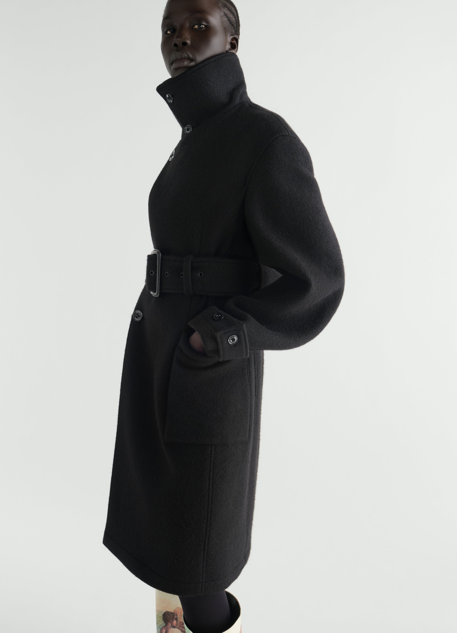Fitted black felted wool and alpaca blend wrap coat with belt worn by model lemaire side view