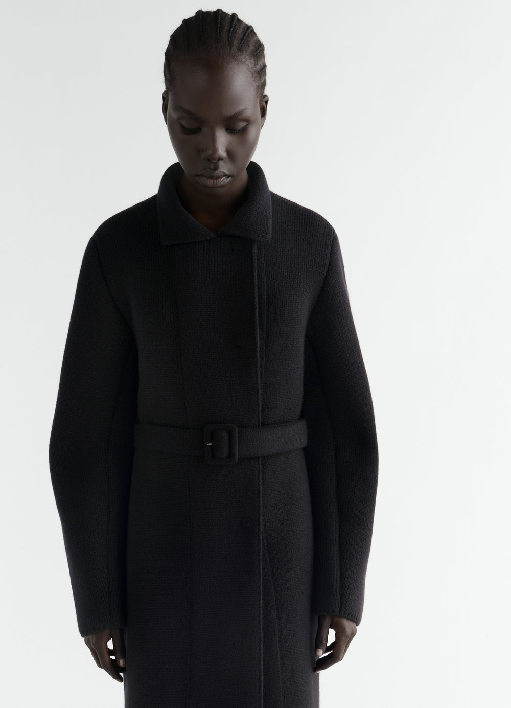 Black double-face felted wool coat with belt worn by model front LEMAIRE