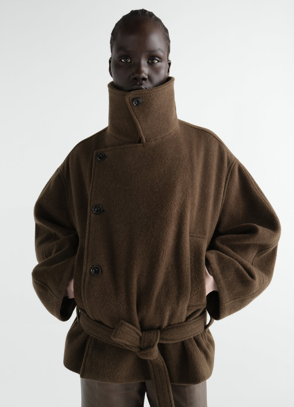 Short brown wool and alpaca blend wrap coat with belt and high collar worn by model LEMAIRE