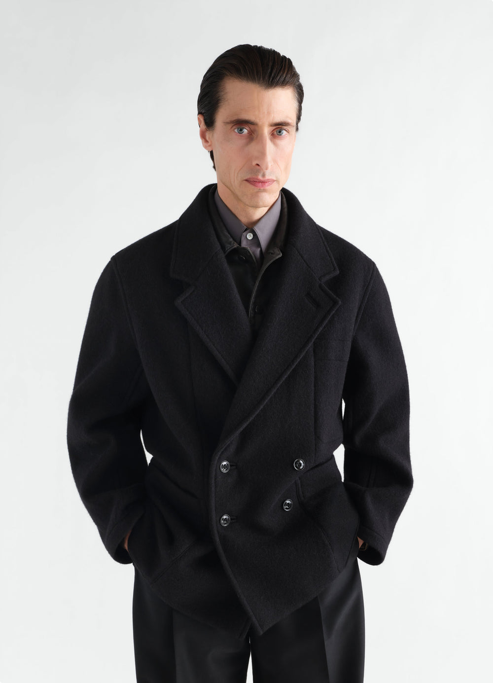 Manteau court à double boutonnage en mélange de laine et alpaga feutré, coloris noir, porté par un mannequin, vue de face