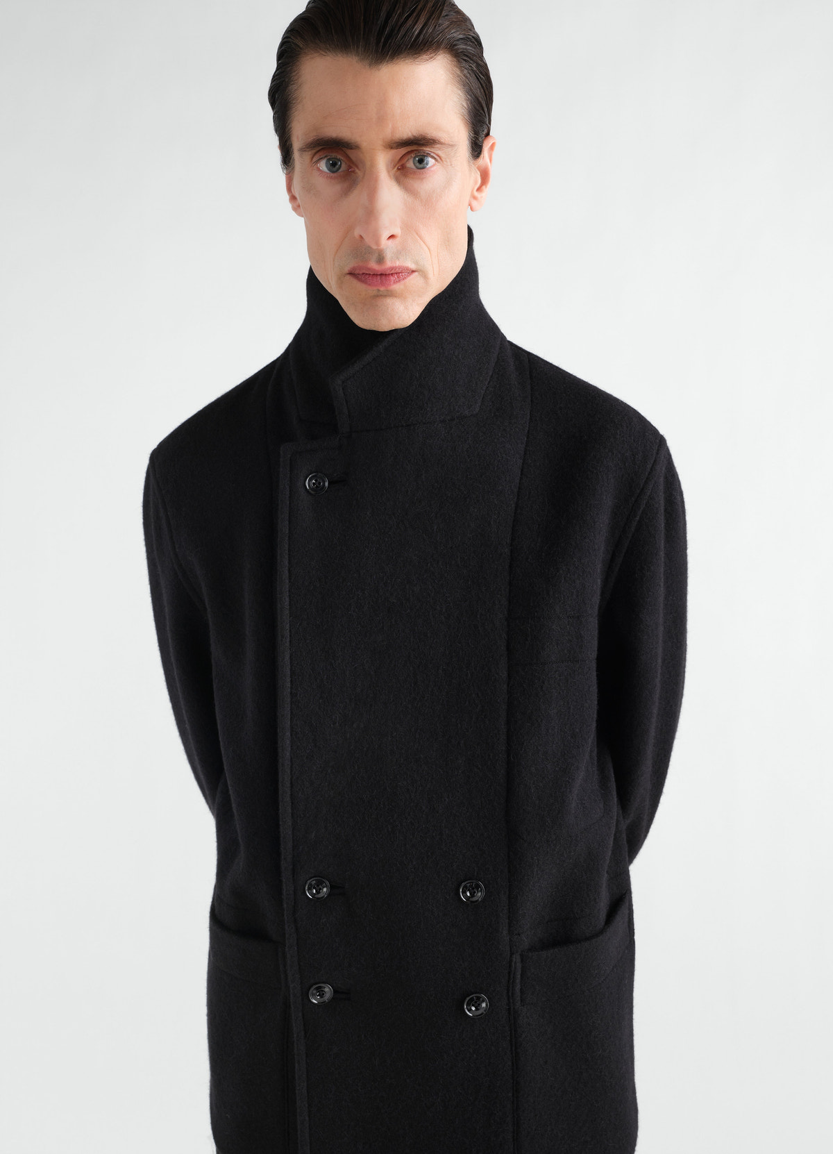 Manteau court à double boutonnage en mélange de laine et alpaga feutré, coloris noir, porté par un mannequin, vue de face