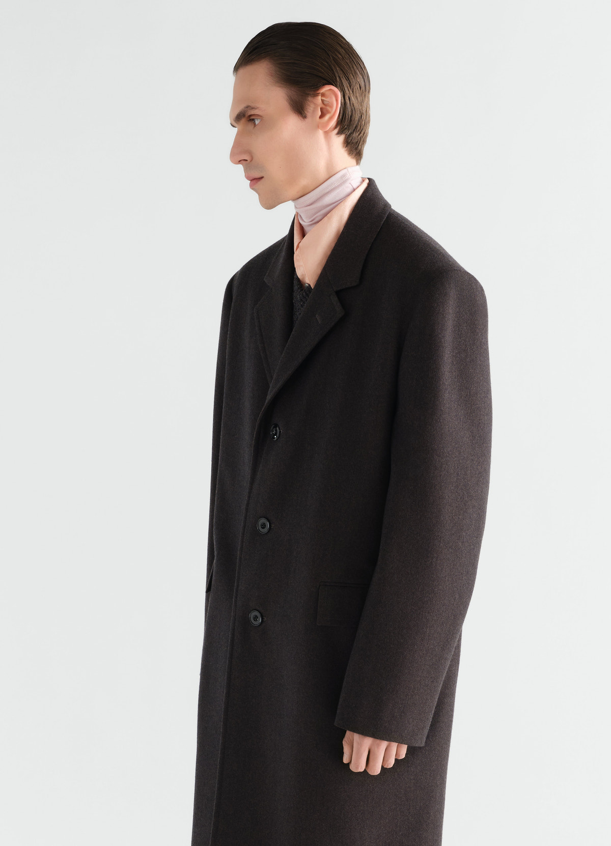 Soft black wool-cotton chesterfield coat lemaire worn by model side view with pink scarf and blush shirt