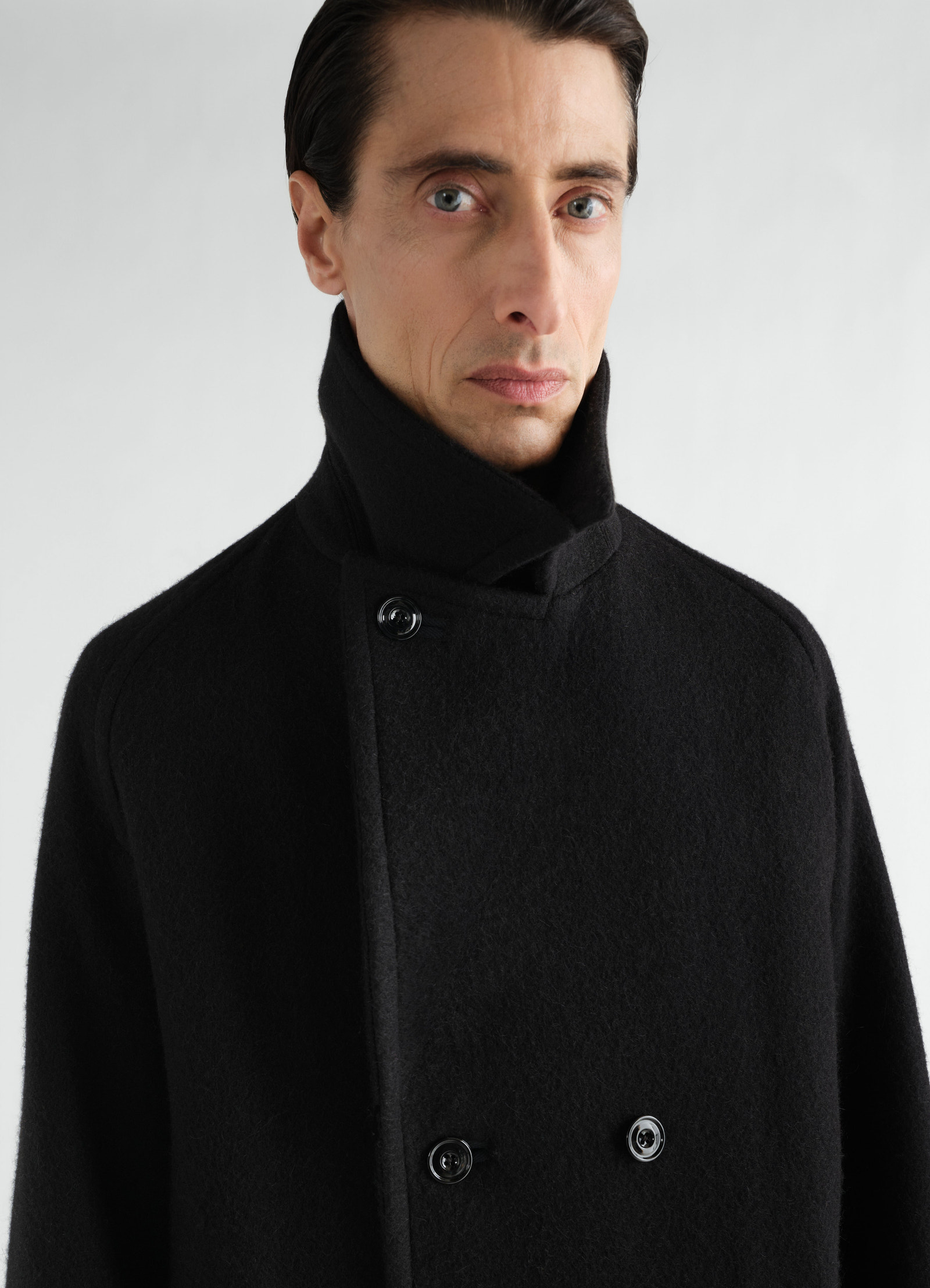 Manteau à double boutonnage en mélange de laine et alpaga feutré, coloris noir, porté par un mannequin, vue de face, col visible