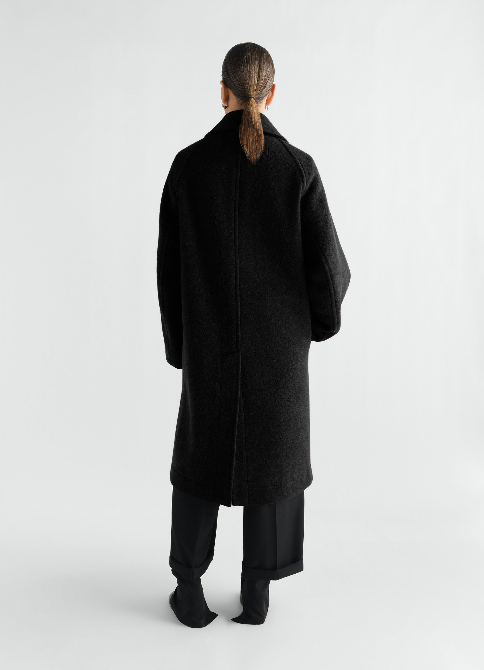 Manteau à double boutonnage en mélange de laine et alpaga feutré, coloris noir, porté par un mannequin, vue de dos