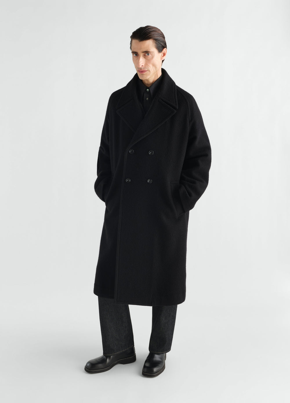 Manteau à double boutonnage en mélange de laine et alpaga feutré, coloris noir, porté par un mannequin, vue de face, poches visibles
