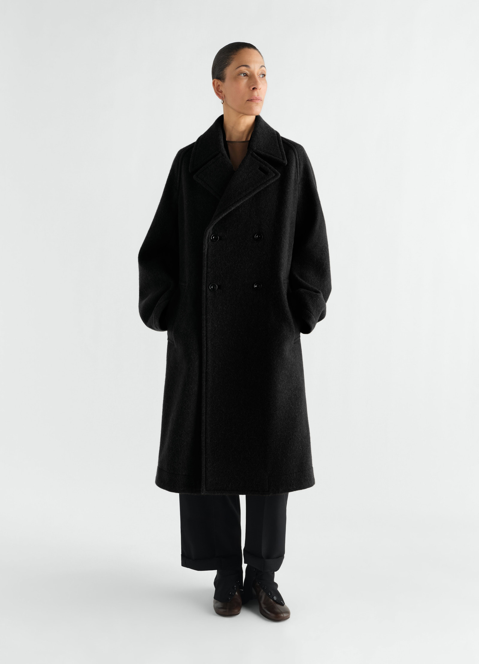 Manteau à double boutonnage en mélange de laine et alpaga feutré, coloris noir, porté par un mannequin, vue de face