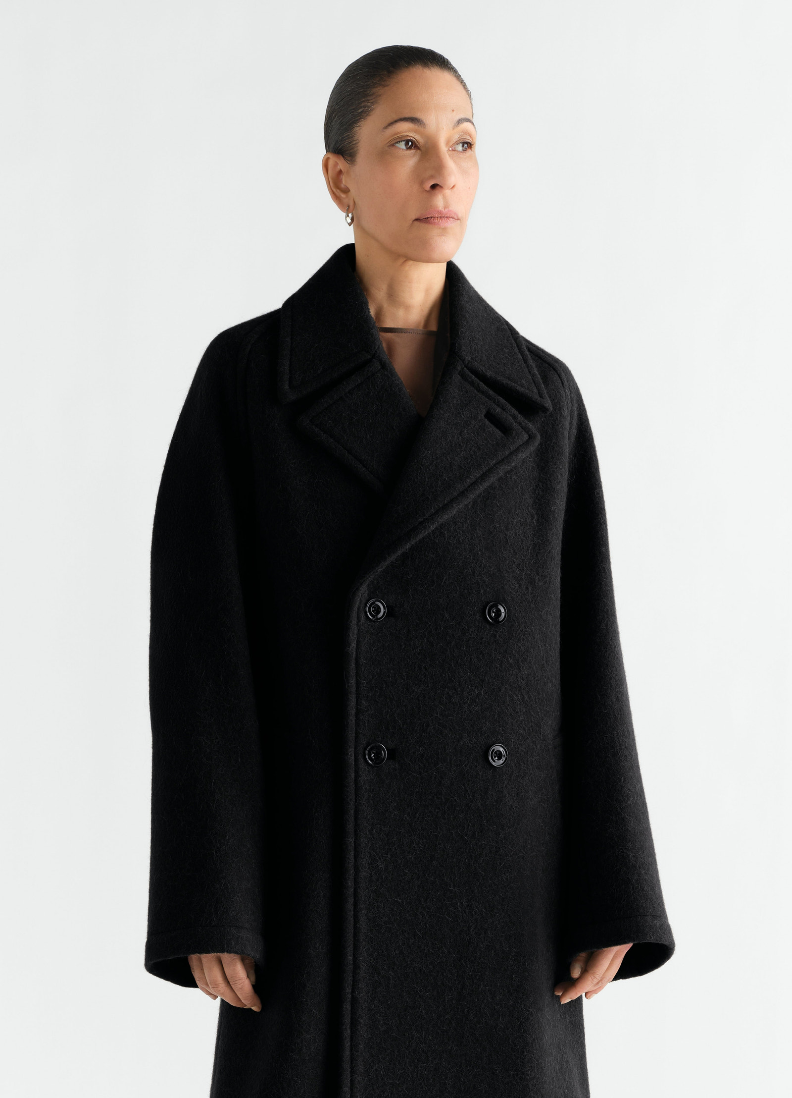 Manteau à double boutonnage en mélange de laine et alpaga feutré, coloris noir, porté par un mannequin, vue de face, boutons visibles