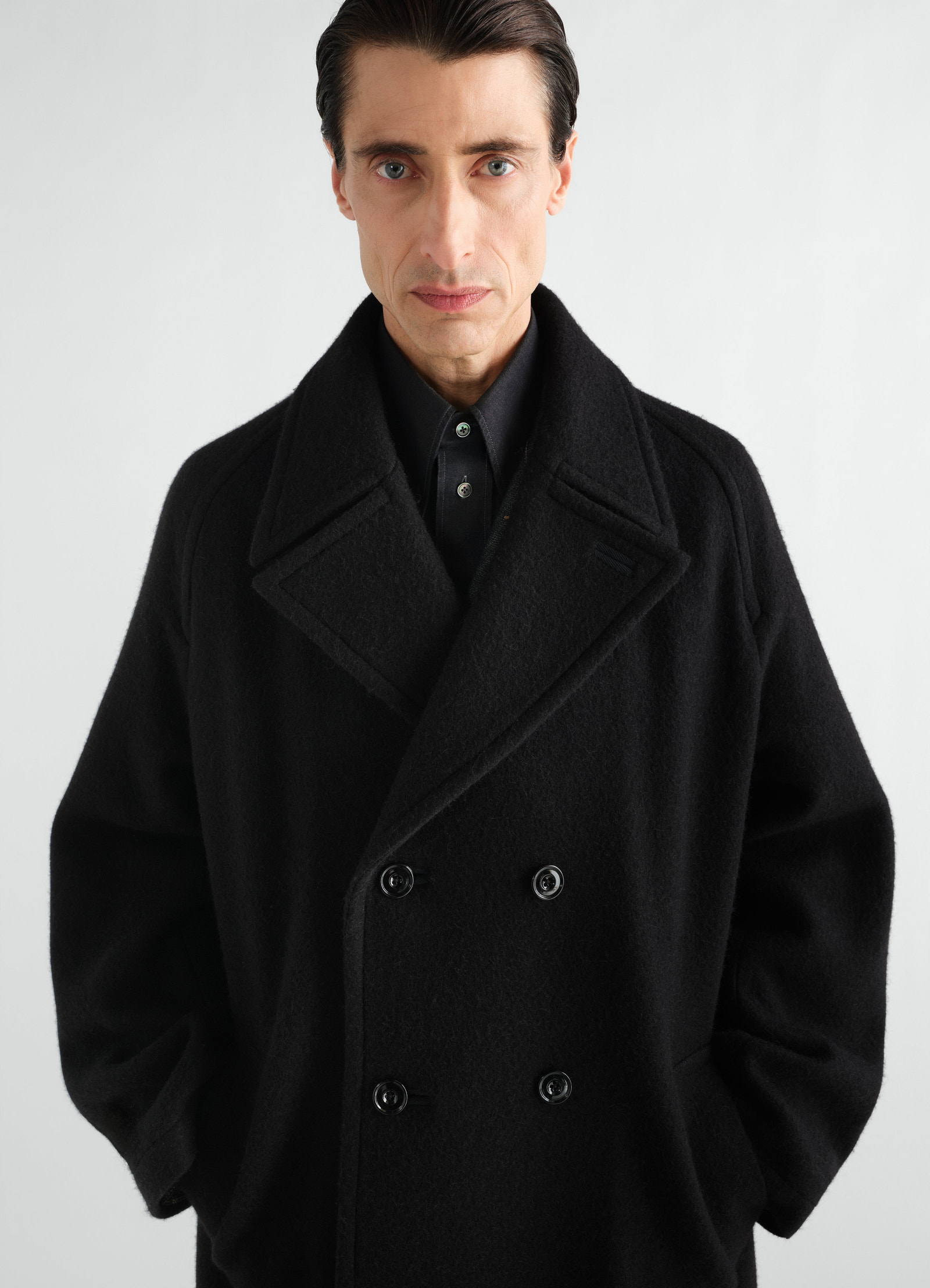 Manteau à double boutonnage en mélange de laine et alpaga feutré, coloris noir, porté par un mannequin, vue de face, poches visibles