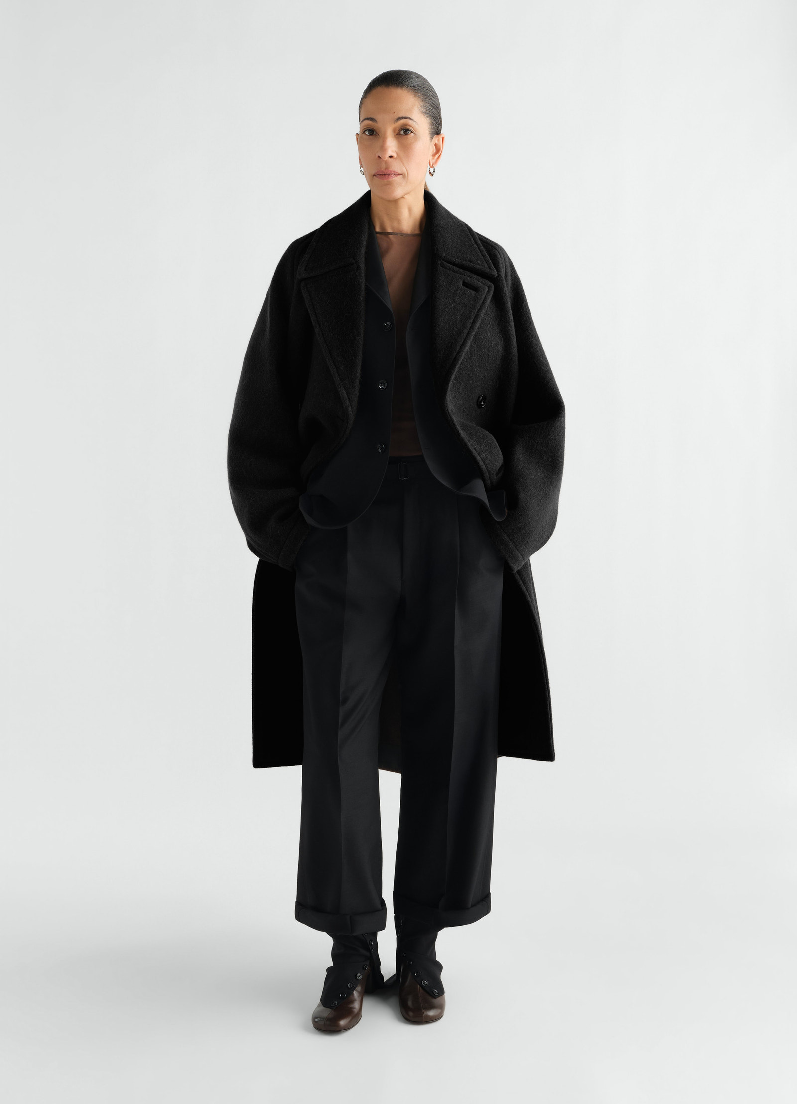 Manteau à double boutonnage en mélange de laine et alpaga feutré, coloris noir, porté par un mannequin, vue de face, poches visibles
