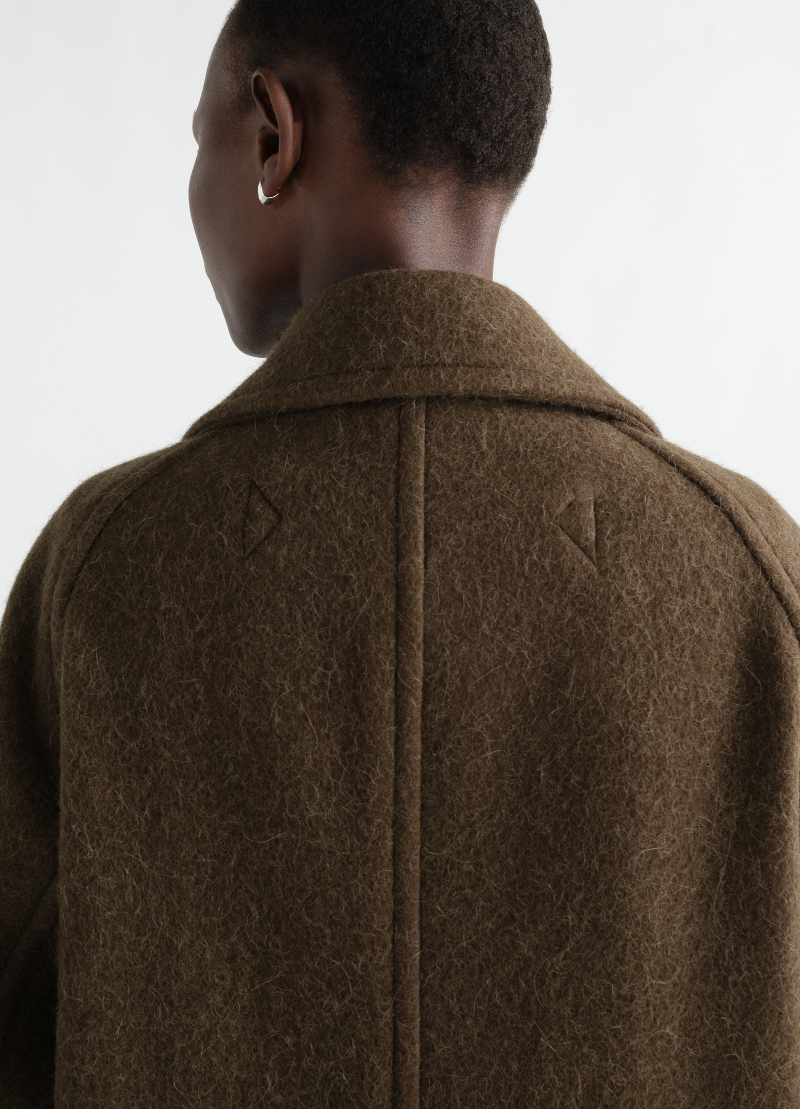 Double-breasted brown felted wool and alpaca blend coat by lemaire worn by model back view close-up detail