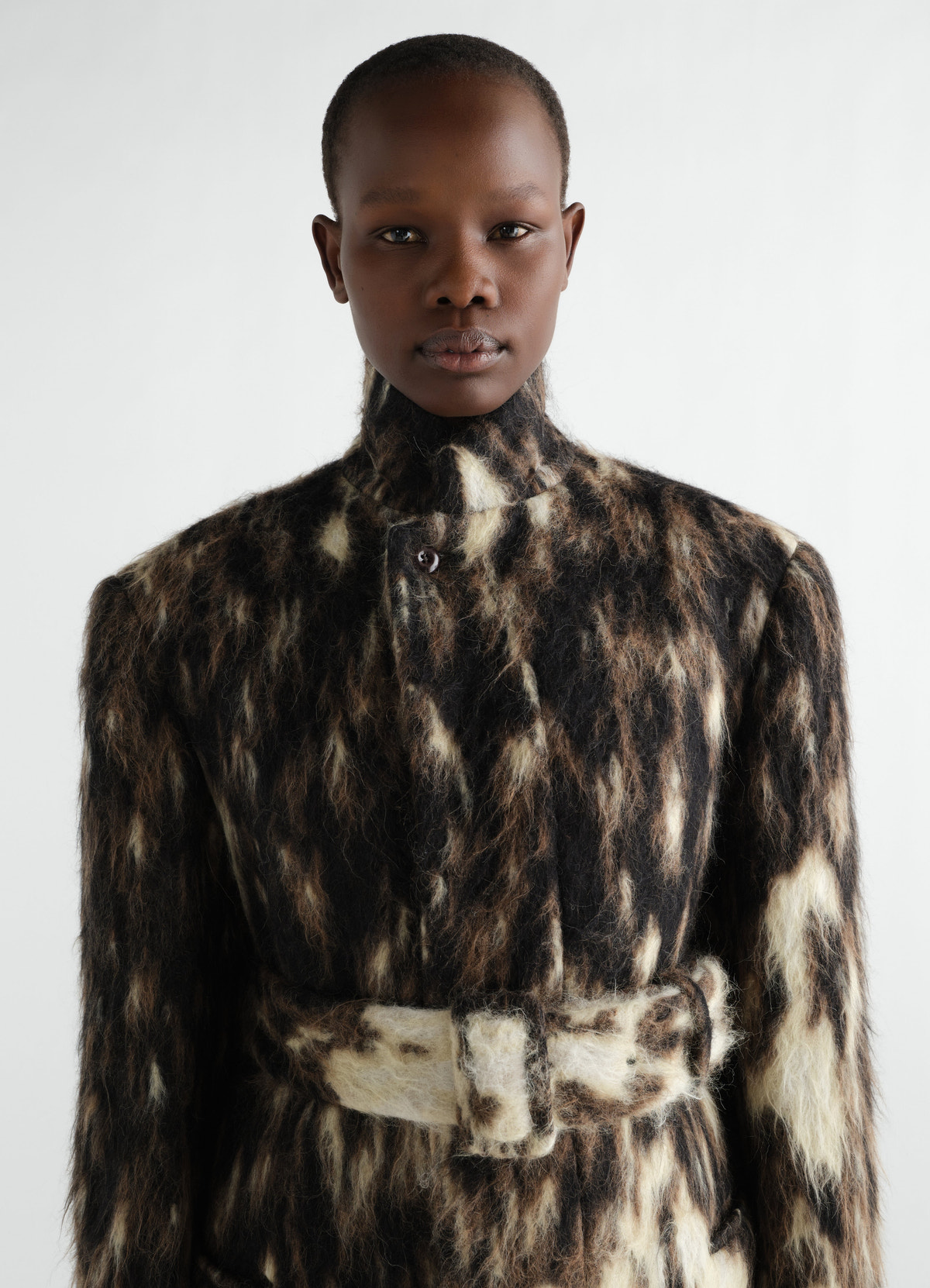 Belted chesterfield coat lemaire in black and beige wool alpaca blend worn by a model front view close-up