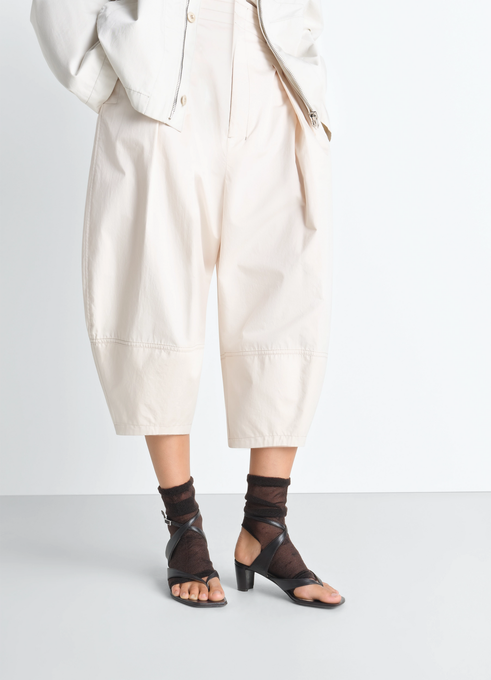 Lemaire tulle gaiters in brown and black tulle, model shot, side profile view ankle-length wrap style