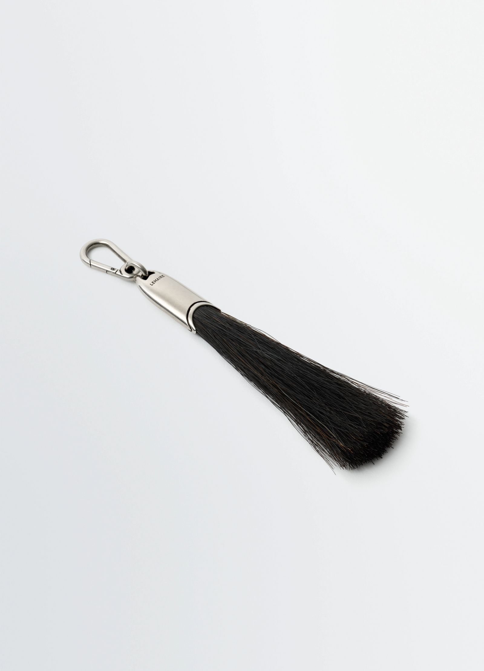 Maxi brush bag charm in horsehair, product shot, angled top view sleek tassel silhouette