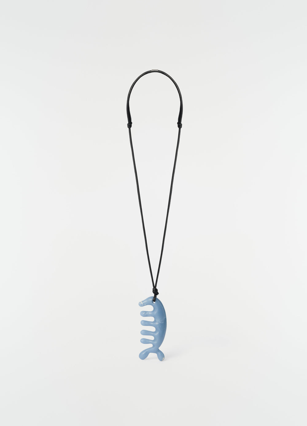 Beluga gua sha necklace in angelite blue ceramic with black cord by LEMAIRE on plain white background