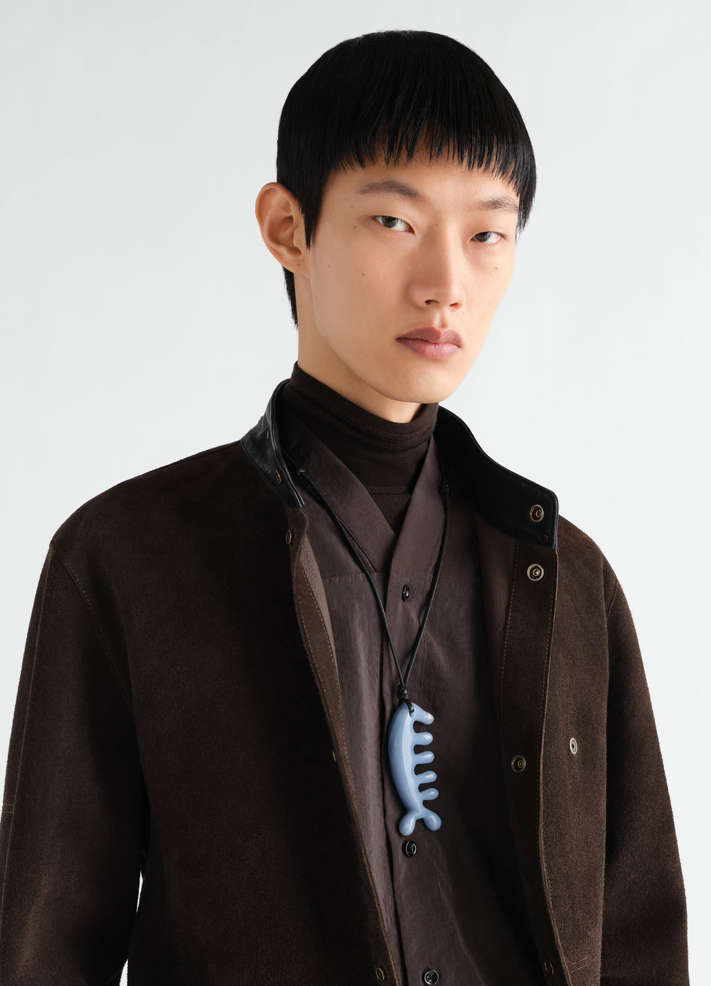 Beluga gua sha angelite necklace worn by model with brown jacket and shirt LEMAIRE front close-up