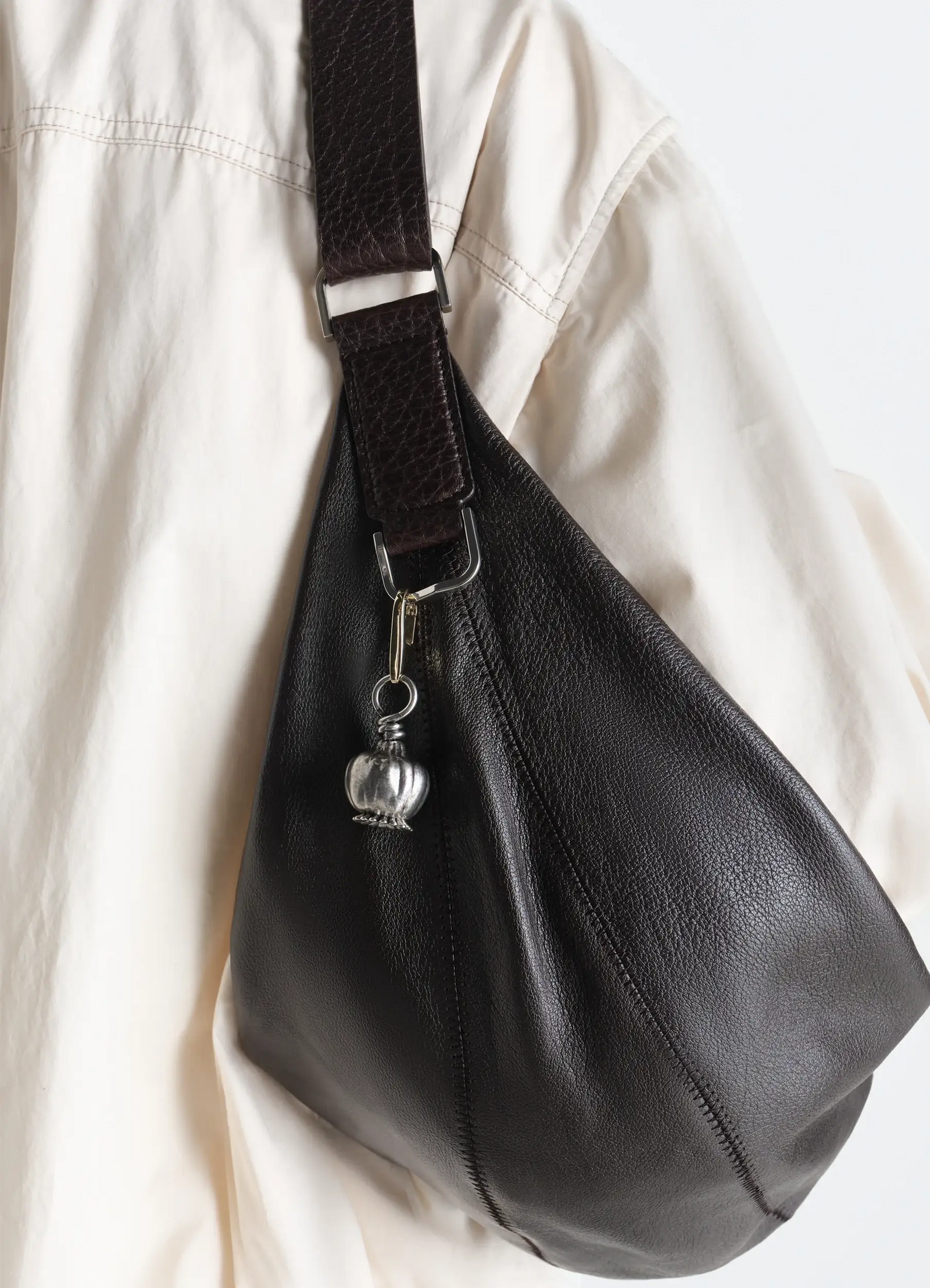 Lemaire maxi thistle bag charm in silver antiqued metal, model shot, side view attached to strap