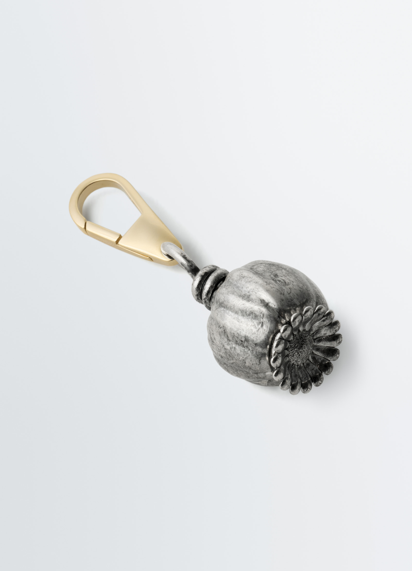 Maxi thistle bag charm by lemaire in aged silver with brass clasp, close-up on plain white background