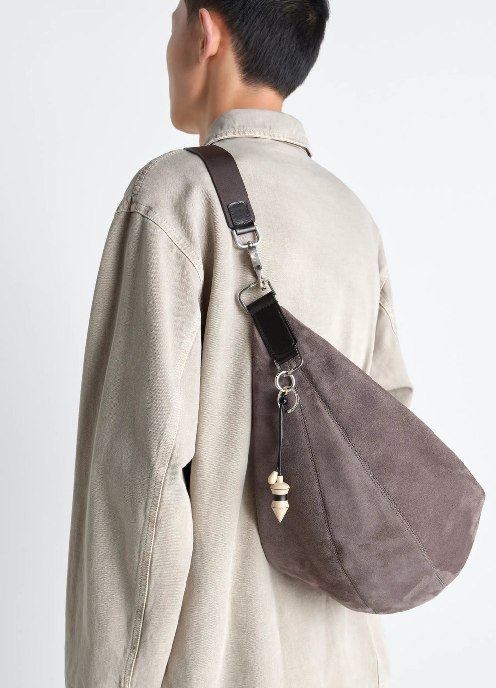 Pendulum Bag Charm in Black Stripes Wood, model shot, back view over shoulder styling