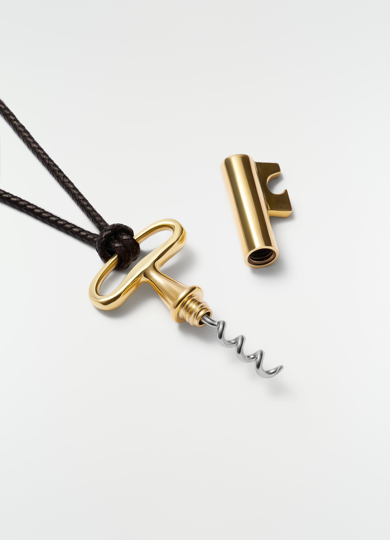 Auböck corkscrew charm in gold stainless steel with brown braided leather cord lemaire styled flat lay
